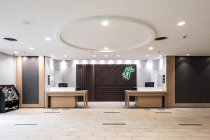 een lobby met twee tafels en een groot scherm bij Holiday Inn Newark International Airport in Newark