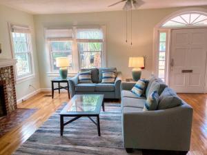 a living room with two couches and a fireplace at University House - 8 Bedrooms Walk to UF / Stadium in Gainesville