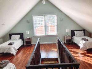 a attic room with two beds and a staircase at University House - 8 Bedrooms Walk to UF / Stadium in Gainesville