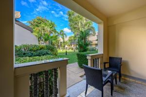 un balcone con 2 sedie e palme di Centara Kata Resort Phuket a Kata Beach