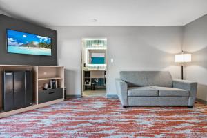 a living room with a couch and a flat screen tv at Avania Inn of Santa Barbara in Santa Barbara