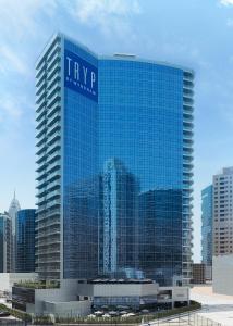 ein hohes blaues Gebäude mit einem Schild drauf in der Unterkunft TRYP by Wyndham Dubai in Dubai