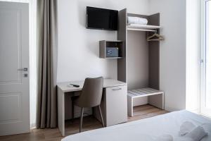 een slaapkamer met een bureau en een tv aan de muur bij City Gallery Apartments in Trieste