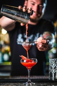 a bartender is pouring a red drink into a martini glass at Plaza Hotel & Casino in Las Vegas