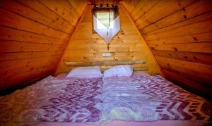 a bedroom with a bed in a wooden cabin at Glamping hišice Orlič in Muta