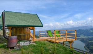 a deck with two chairs on top of a mountain at Glamping hišice Orlič in Muta