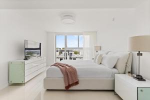 a white bedroom with a white bed and a window at Bay Harbor One Vacation in Miami Beach