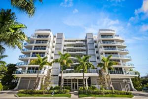 a building with palm trees in front of it at Bay Harbor One Vacation in Miami Beach