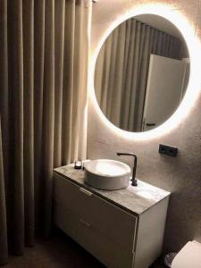 La salle de bains est pourvue d'un lavabo et d'un miroir. dans l'établissement Keflavik Luxury apartment - KLA, à Keflavík