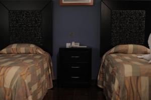 a bedroom with two beds and a black dresser at Hotel Plaza Delta in Mexico City