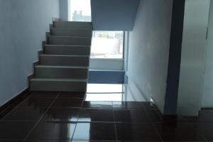 a hallway with a staircase with a window and a tile floor at Hotel Plaza Delta in Mexico City