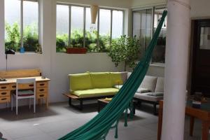 eine Hängematte in einem Zimmer mit einem Sofa und einem Tisch in der Unterkunft 5th Element Beach House Caparica in Costa da Caparica