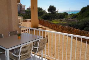 balcone con tavolo, sedie e vista sull'oceano di Apartments Es Trenc a Ses Covetes