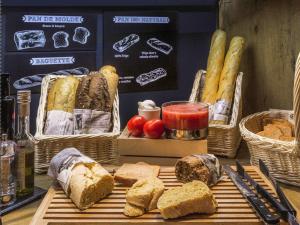 uma mesa com cestos de pão e outros alimentos em ibis Strasbourg Centre Historique em Estrasburgo