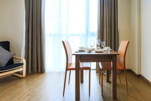 a dining room table with chairs and wine glasses on it at Aurora Serviced Apartments in Ho Chi Minh City