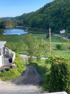 a road leading to a lake and a house at Anneks i naturskjønne Gitlevåg in Lyngdal