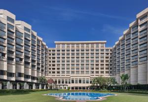 um grande edifício com uma piscina em frente em Hyatt Regency Delhi em Nova Deli