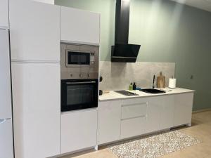 cocina blanca con fogones y microondas en Estudio canela, en Melilla