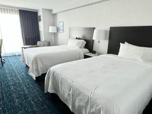 2 łóżka w pokoju hotelowym z białą pościelą w obiekcie Chelsea Hotel Toronto w mieście Toronto