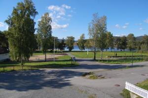 an empty parking lot with trees and a lake at Hamresanden Resort in Kristiansand