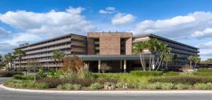 een groot bakstenen gebouw met palmbomen ervoor bij Rosen Inn International Near The Parks in Orlando