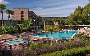 een zwembad in een resort met palmbomen en een gebouw bij Rosen Inn International Near The Parks in Orlando