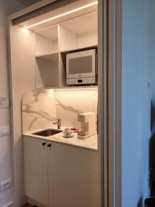 a small kitchen with a sink and a microwave at Sempione Boutique Hotel in Stresa