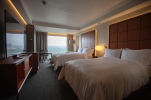 a hotel room with two beds and a television at Grand Fiesta Americana Chapultepec in Mexico City