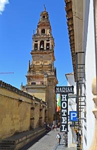 un edificio alto con una torre de reloj en el fondo en Hotel Marisa, en Córdoba