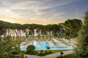 uma imagem de uma piscina com espreguiçadeiras e árvores em Falkensteiner Hotel Adriana - Adults Only em Zadar