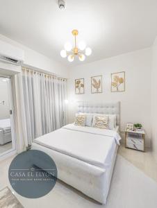 um quarto branco com uma cama e uma ventoinha de tecto em White Nordic Fully-Furnished Studio at INSPIRIA em Dávao