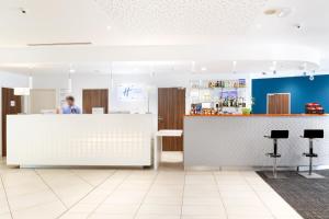 土伦Holiday Inn Express Toulon - Est, an IHG Hotel的站在厨房柜台上的人