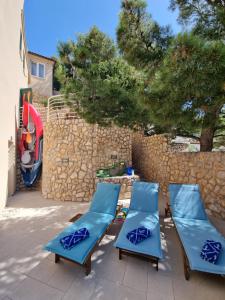 un gruppo di sedie a sdraio blu su un patio di Villa Relax , with seaview and two pools near beach a Starigrad (Cittavecchia)