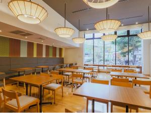 a restaurant with tables and chairs and large windows at Hotel Gracery Kyoto Sanjo in Kyoto