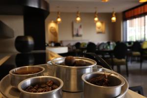 three metal pots filled with nuts on a table at Safir Fintas Hotel Kuwait in Kuwait