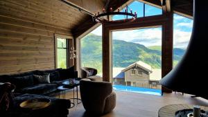 uma sala de estar com um sofá e uma grande janela em Mlodge - The Mountain Lodge em Sogndal