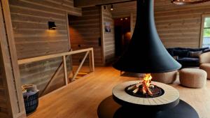 uma lareira numa sala de estar com um candeeiro preto em Mlodge - The Mountain Lodge em Sogndal