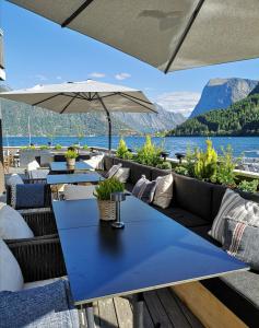 un patio con tavoli e sedie e vista sul lago di Sagafjord Hotel - by Classic Norway Hotels a Sæbø