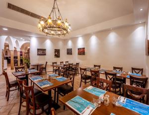 une salle à manger avec des tables et des chaises ainsi qu'un lustre dans l'établissement Hagoshrim Hotel & Nature, à Hagoshrim