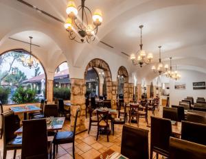 un restaurant avec des tables, des chaises et des lustres dans l'établissement Hagoshrim Hotel & Nature, à Hagoshrim