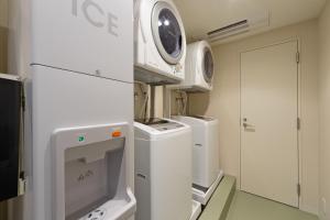 a kitchen with a washing machine and a microwave at Hotel Gran Ms Kyoto in Kyoto