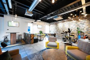 a room with tables and chairs and a brick wall at Staycity Aparthotels Birmingham Jewellery Quarter in Birmingham