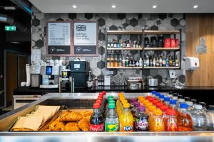 a counter with drinks and pastries and soda bottles at Staycity Aparthotels Birmingham Jewellery Quarter in Birmingham