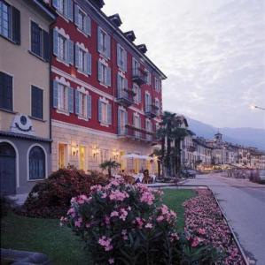 um grupo de edifícios numa rua com flores em Hotel Cannobio em Cannobio