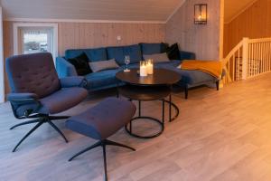 ein Wohnzimmer mit einem blauen Sofa und einem Tisch in der Unterkunft Lofoten Waterfront luxury lodge in Ballstad