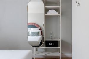 a mirror in a white room with a bed at Numa I Portico in Rome