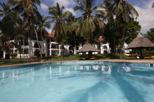 una piscina frente a una casa con palmeras en Cocoa Luxury Resort, Nyali, Mombasa, en Mombasa