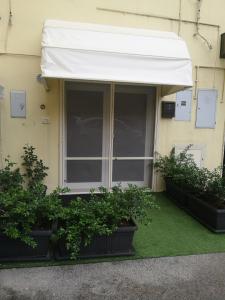 un toldo blanco al lado de un edificio con plantas en L'angolo di Cinzia, en Matera