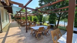 a wooden deck with tables and chairs and a pergola at Aquasole in Mercallo