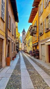 uma rua da cidade com uma torre do relógio à distância em Hotel Casa Arizzoli em Cannobio